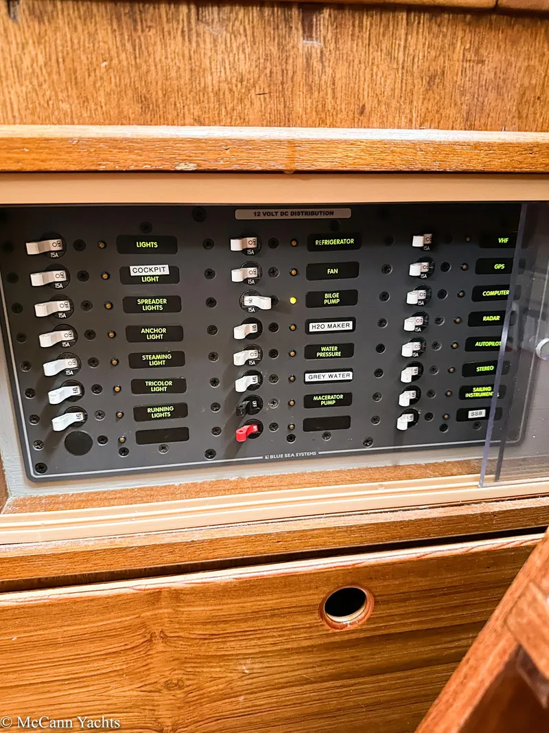 Slide: The Image of Electrical control panel on a 1973 Challenger 40 yacht, featuring labeled switches and wooden casing. - 37