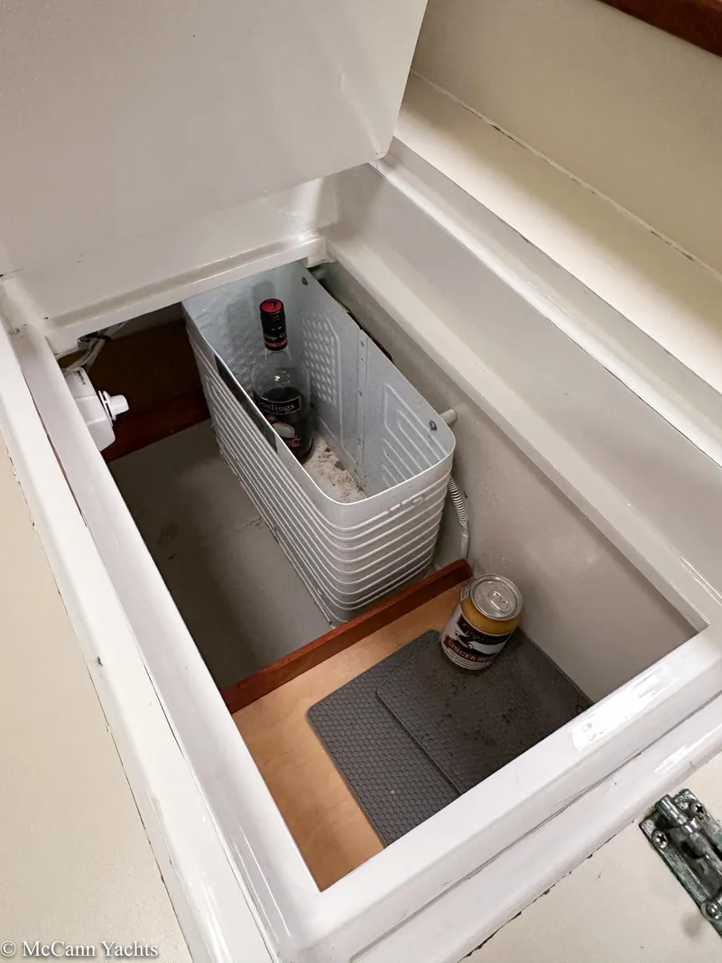 Slide: The Image of Storage compartment in a 1973 Challenger 40 boat with beverages and a basket. - 40