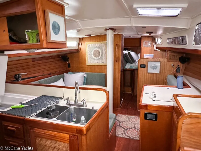 Slide: The Image of 1973 Challenger 40 yacht interior with wood finish, kitchenette, and cozy seating area. - 42