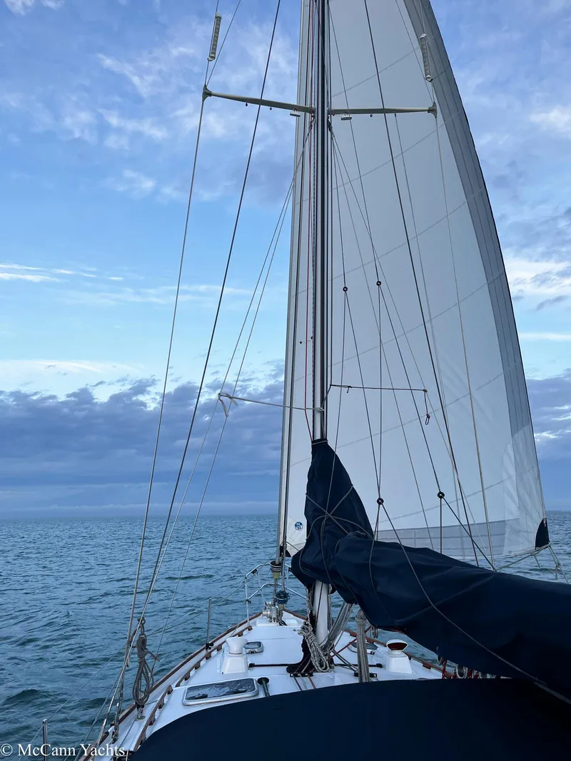Slide: The Image of 1973 Challenger 40 sailboat navigating calm seas under a clear blue sky. - 9