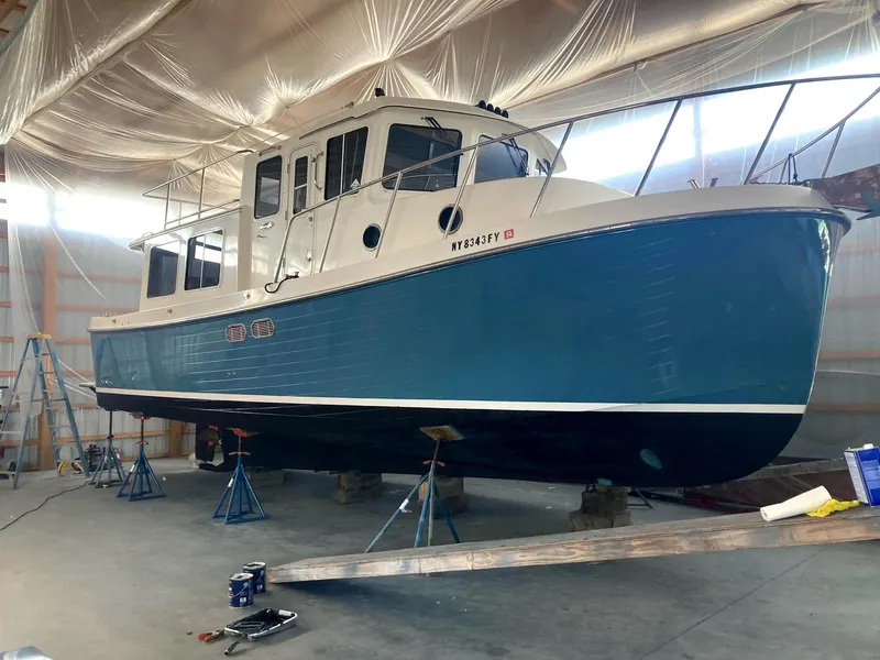 The Image of 2003 American Tug 34 boat in a storage facility, elevated on stands. - 1