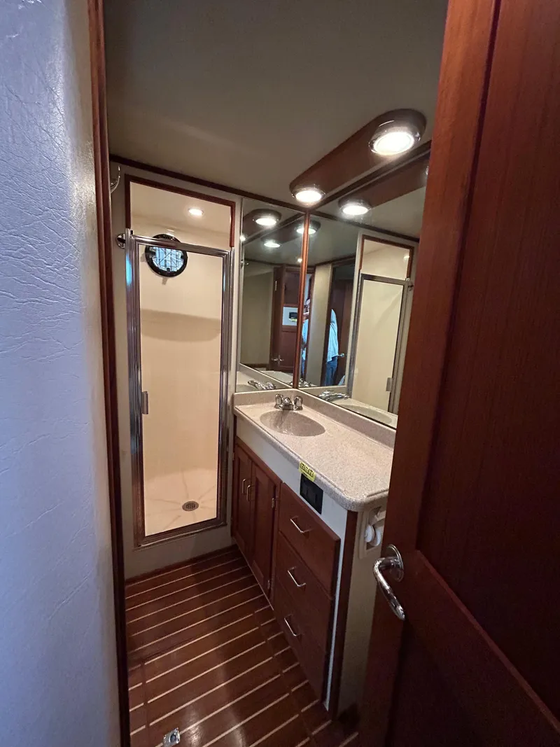 Slide: The Image of 2003 American Tug 34 bathroom with wood accents, shower, and vanity. - 11