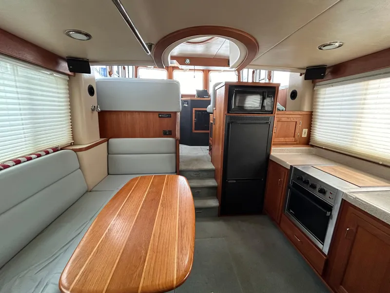 Slide: The Image of Interior of 2003 American Tug 34, featuring dining area, kitchen, and modern appliances. - 5