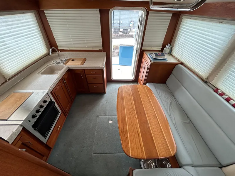 Slide: The Image of Interior of 2003 American Tug 34, featuring kitchen and dining area with wood finishes. - 6