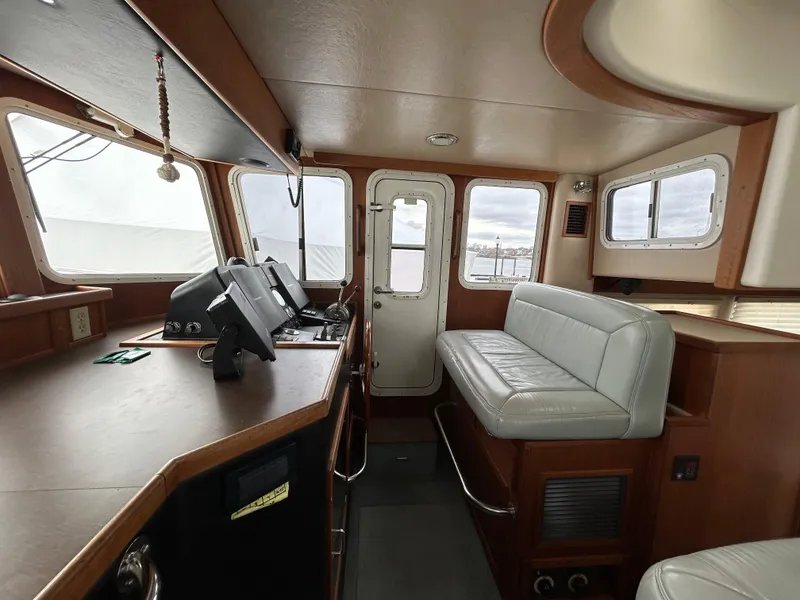 Slide: The Image of Interior of 2003 American Tug 34, featuring helm and seating area. - 8