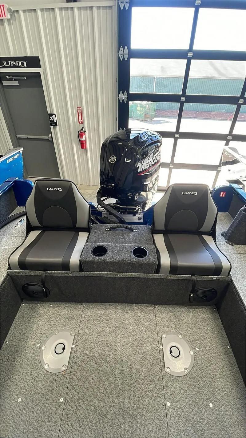 Slide: The Image of 2025 Lund 1650 Rebel XL Sport boat interior with seating and motor. - 5