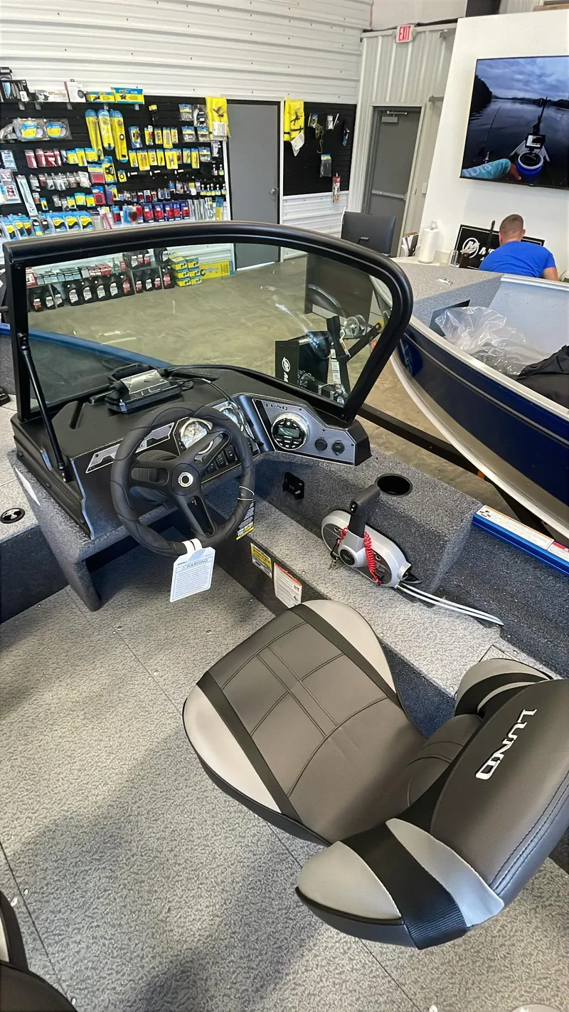 Slide: The Image of 2025 Lund 1650 Rebel XL Sport boat interior with steering wheel and seating. - 7