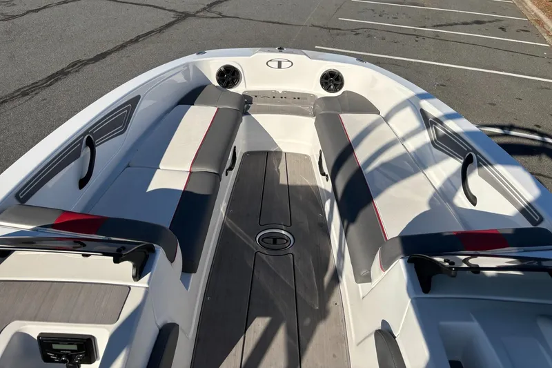 Slide: The Image of 2024 Tahoe T21 boat interior with seating and speakers, parked on pavement. - 11