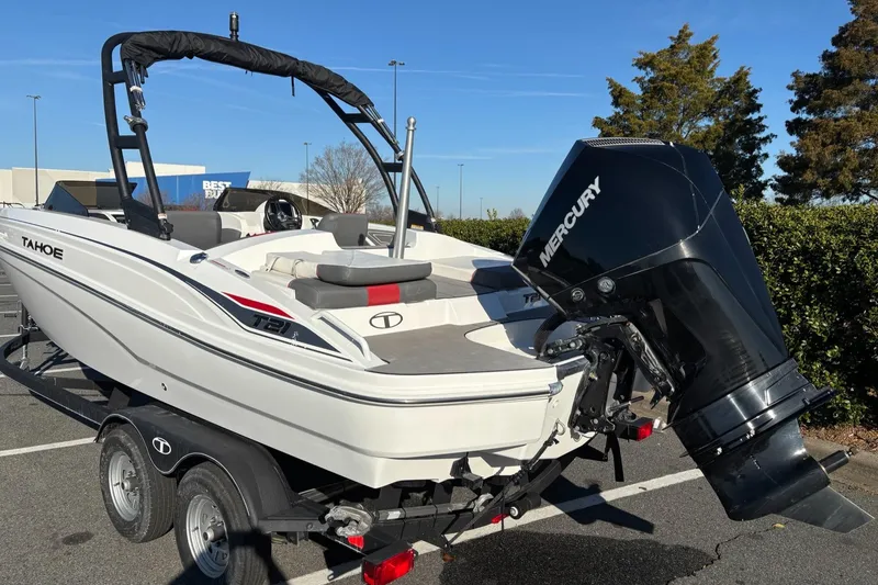 Slide: The Image of 2024 Tahoe T21 boat with Mercury engine on a trailer in a parking lot. - 2