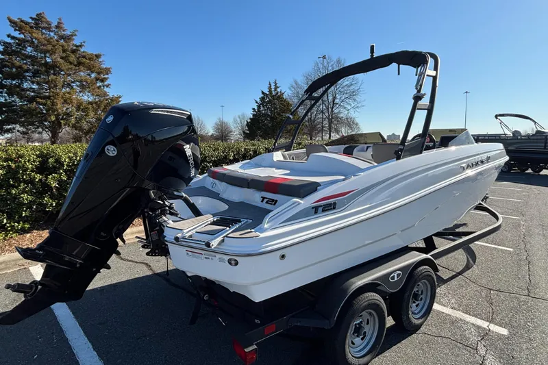Slide: The Image of 2024 Tahoe T21 boat on trailer, parked outdoors, featuring sleek design and powerful outboard motor. - 4