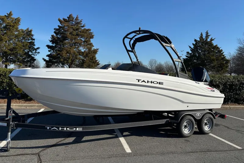 Slide: The Image of 2024 Tahoe T21 boat on trailer in parking lot, surrounded by trees. - 7