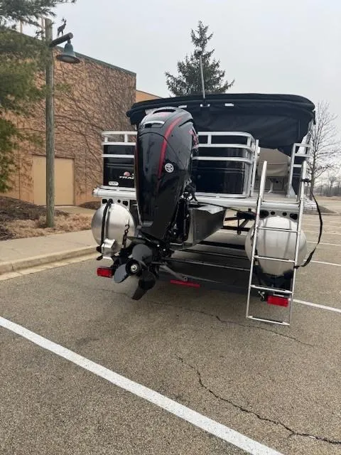 Slide: The Image of 2025 Sun Tracker SportFish 22 DLX pontoon boat with outboard motor in parking lot. - 8