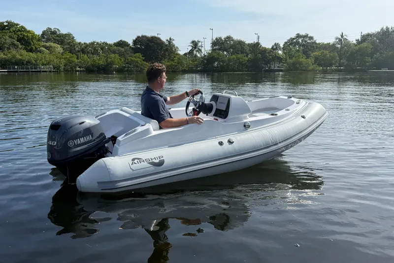The Image of Man operating 2025 Airship 115 boat with Yamaha engine on calm water. - 1