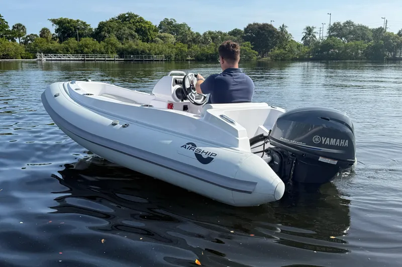 Slide: The Image of Man driving Airship 115 boat with Yamaha engine on a calm lake, 2025 model. - 5