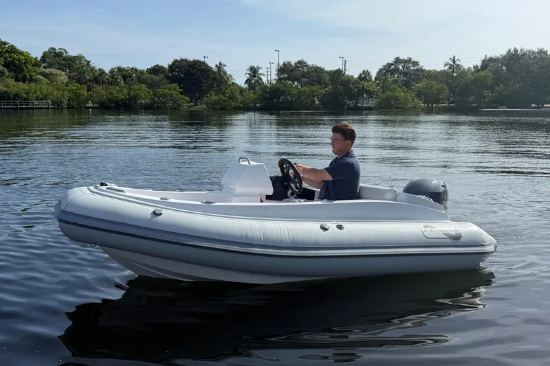 Slide: The Image of Man steering Airship 115 inflatable boat on a calm lake, 2025 model. - 6