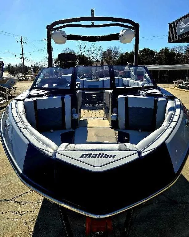 Slide: The Image of 2025 Malibu Wakesetter 23 LSV boat, sleek design, parked outdoors under clear sky. - 9
