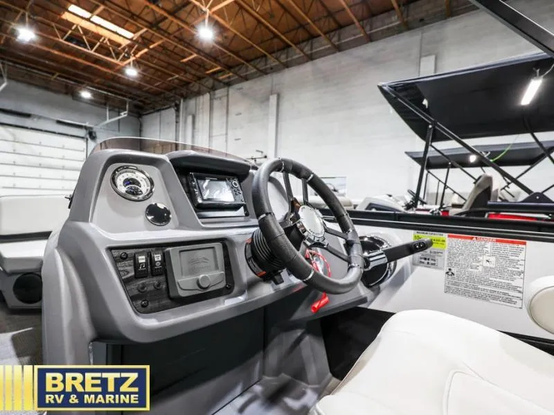 Slide: The Image of 2025 Mirage LZ A-22 SPORT boat dashboard in showroom, featuring steering wheel and controls. - 10