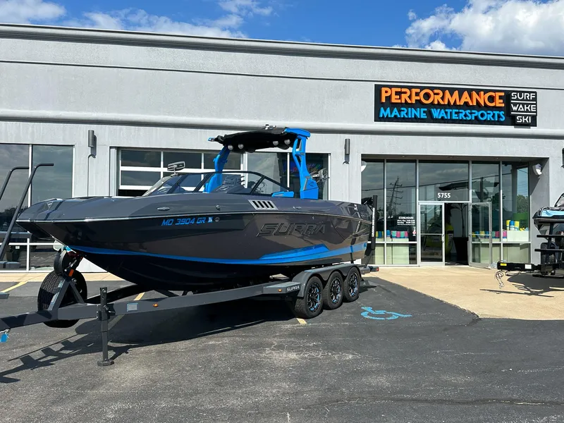 Slide: The Image of 2022 Supra SE boat on trailer outside Performance Marine Watersports store. - 0