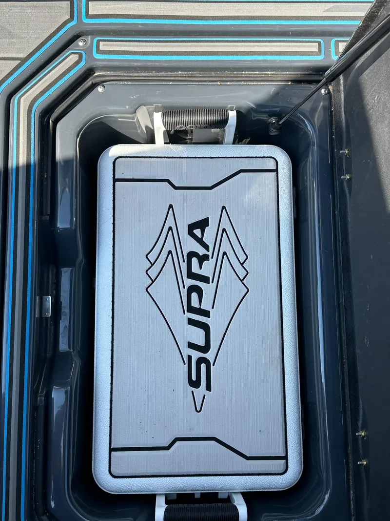 Slide: The Image of 2022 Supra SE storage compartment with sleek design and logo detailing. - 21