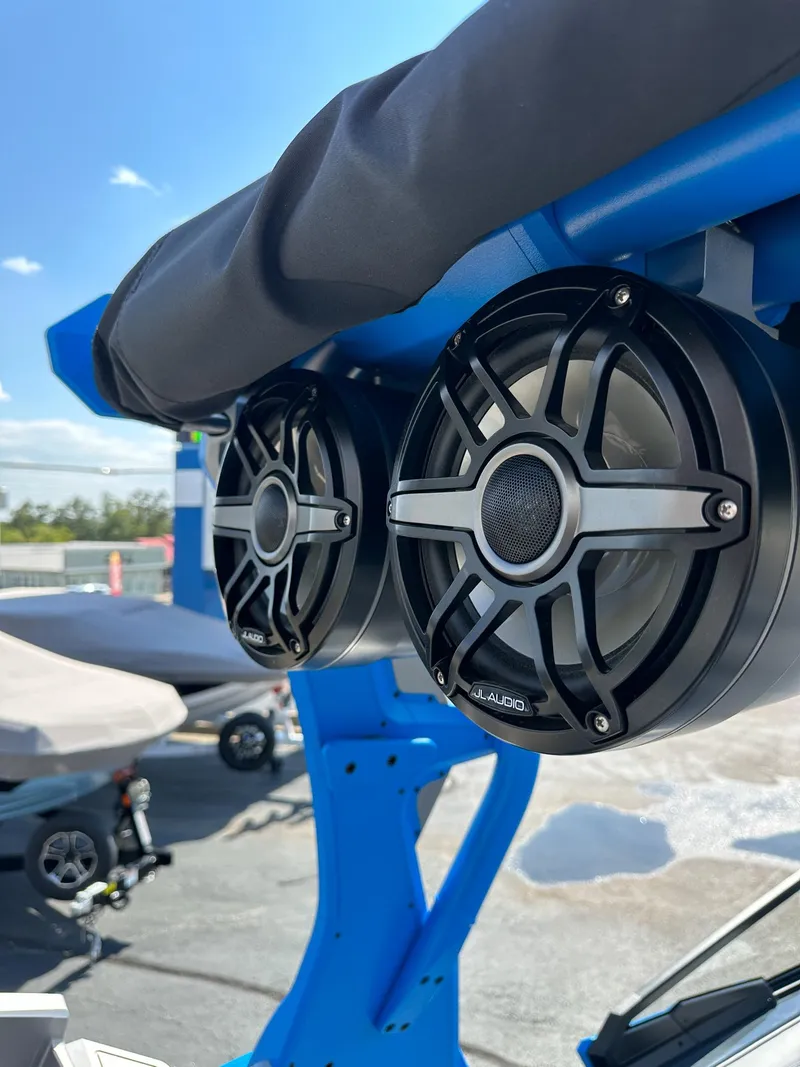 Slide: The Image of 2022 Supra SE boat with mounted speakers, blue frame, and clear sky background. - 27
