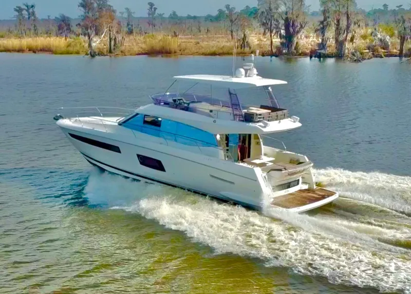 Slide: The Image of 2016 Prestige 550 luxury yacht cruising on a serene river. - 3
