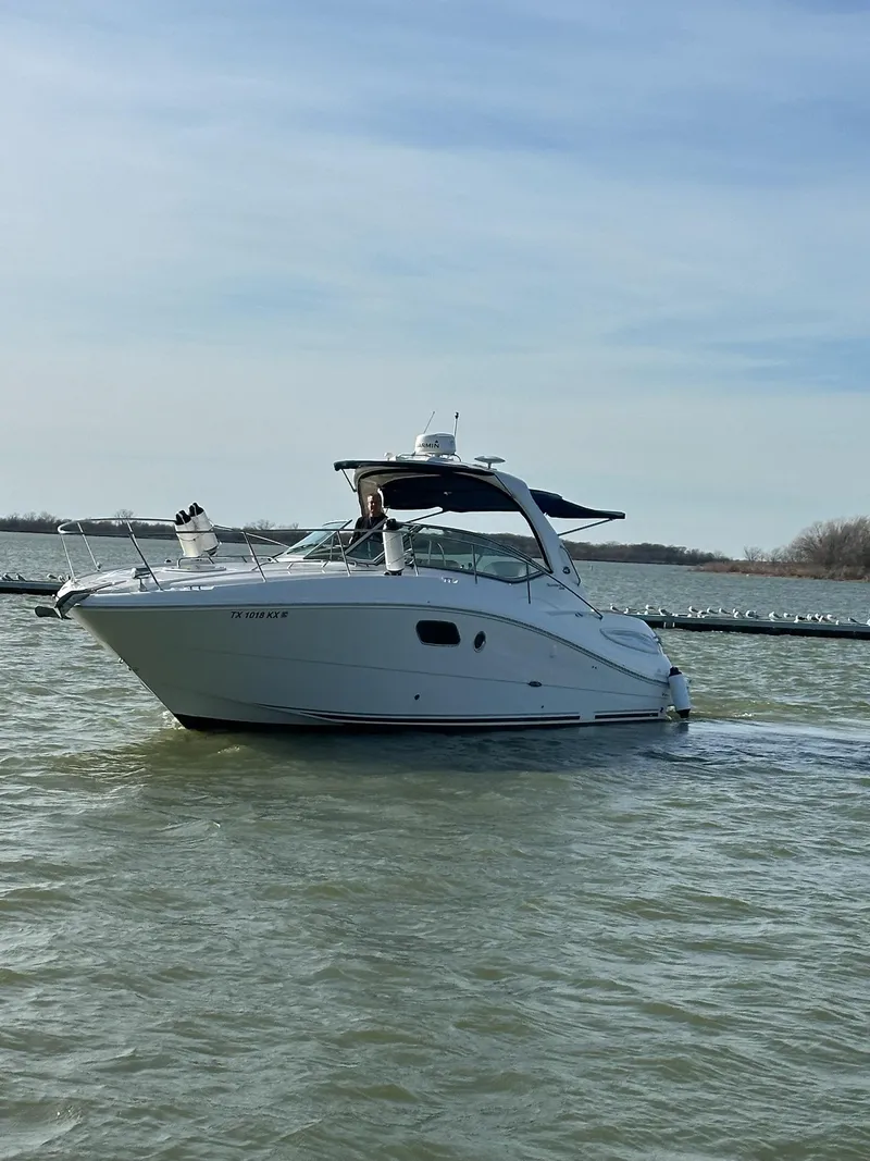 Slide: The Image of 2011 Sea Ray 350 Sundancer cruising on a calm lake under a clear sky. - 10