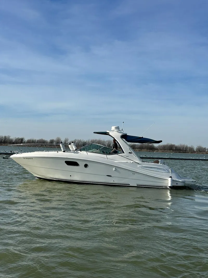 Slide: The Image of 2011 Sea Ray 350 Sundancer yacht cruising on calm waters under a clear blue sky. - 11