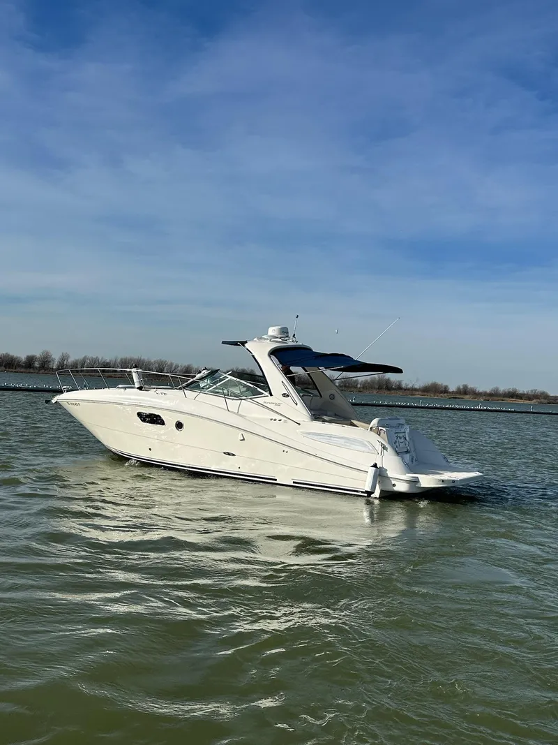 Slide: The Image of 2011 Sea Ray 350 Sundancer cruising on calm waters under a clear blue sky. - 12