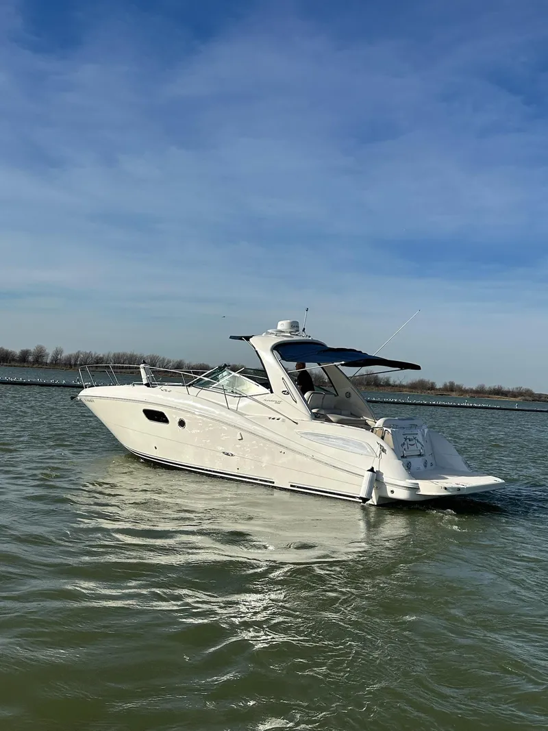 Slide: The Image of 2011 Sea Ray 350 Sundancer cruising on a calm lake under a clear blue sky. - 13