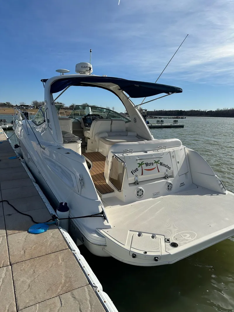 Slide: The Image of 2011 Sea Ray 350 Sundancer docked on a sunny day, showcasing sleek design and spacious deck. - 15