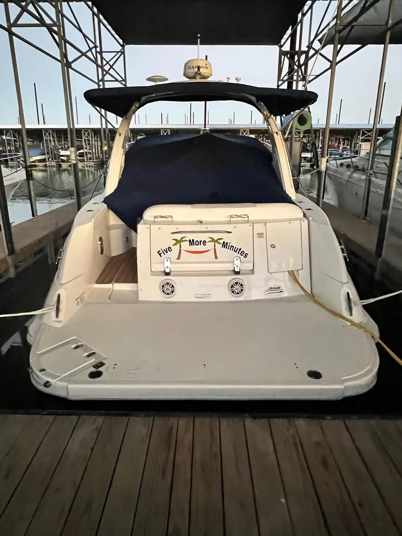 Slide: The Image of 2011 Sea Ray 350 Sundancer docked, rear view with cover, marina setting. - 19