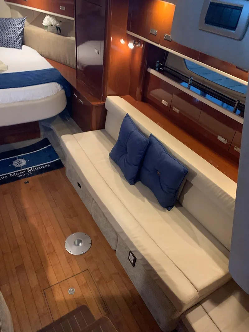 Slide: The Image of Interior of 2011 Sea Ray 350 Sundancer with seating, bed, and wooden flooring. - 23