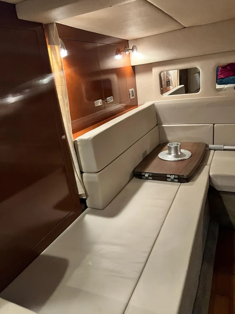 Slide: The Image of Interior of 2011 Sea Ray 350 Sundancer with beige seating and wooden accents. - 35