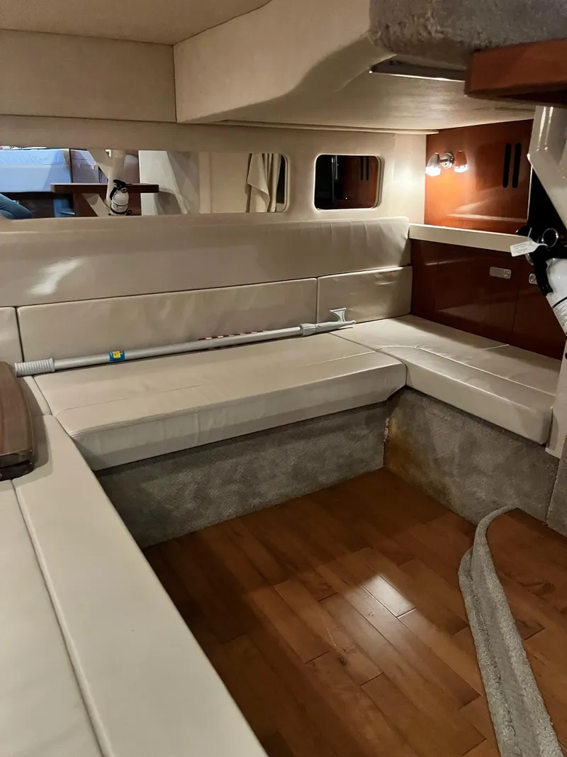 Slide: The Image of 2011 Sea Ray 350 Sundancer cabin interior with beige seating and wooden flooring. - 36