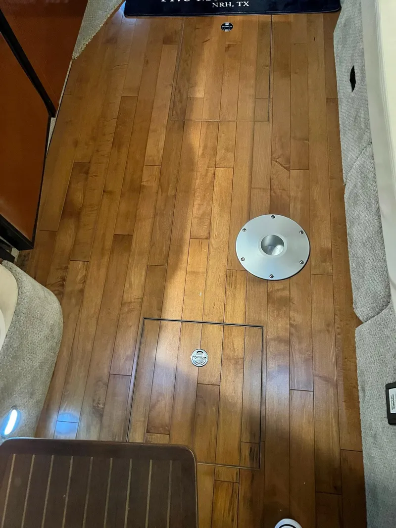 Slide: The Image of Wooden floor inside 2011 Sea Ray 350 Sundancer boat, featuring circular metal fixtures. - 41