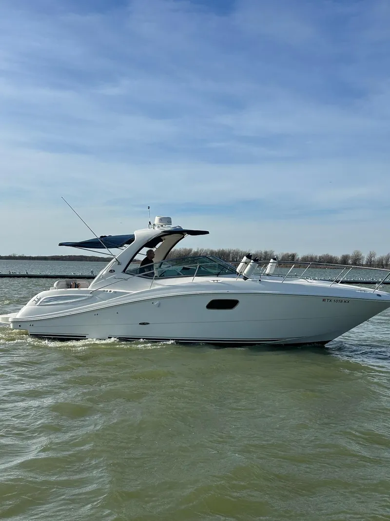 Slide: The Image of 2011 Sea Ray 350 Sundancer cruising on a calm lake under a clear sky. - 8