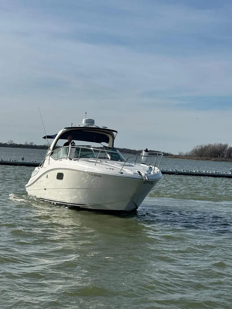 Slide: The Image of 2011 Sea Ray 350 Sundancer cruising on a calm lake under a clear sky. - 9
