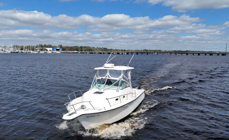 Slide: The Image of 1999 Pursuit 2870 Walkaround boat cruising on a sunny day with blue skies. - 11