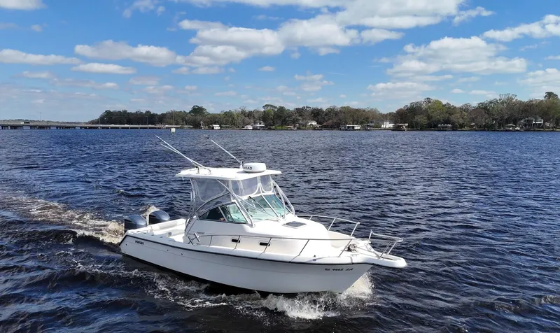 Slide: The Image of 1999 Pursuit 2870 Walkaround boat cruising on a sunny day with blue skies. - 14