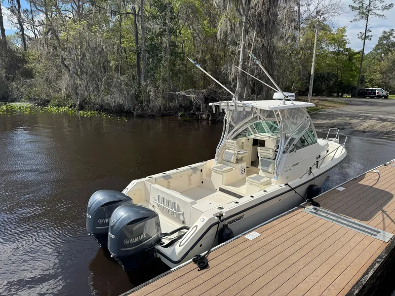 Slide: The Image of 1999 Pursuit 2870 Walkaround boat docked with dual Yamaha engines. - 16