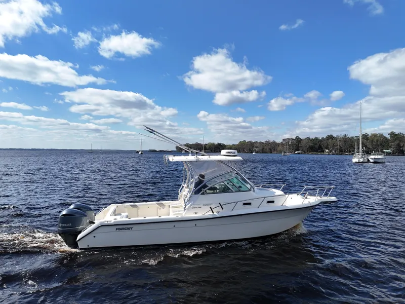 Slide: The Image of 1999 Pursuit 2870 Walkaround boat cruising on a sunny day with blue skies. - 2
