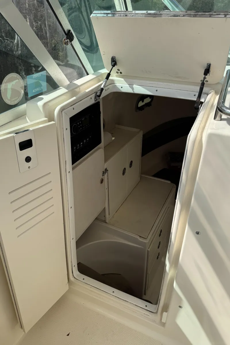 Slide: The Image of 1999 Pursuit 2870 Walkaround cabin interior with storage compartments and seating. - 21