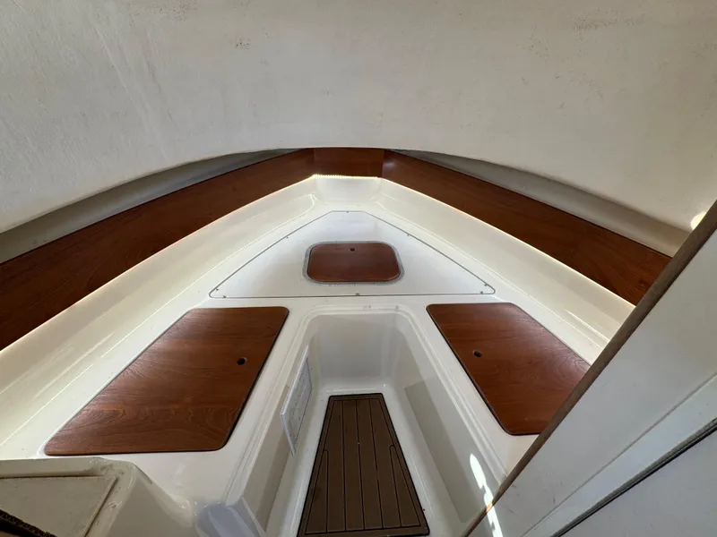 Slide: The Image of 1999 Pursuit 2870 Walkaround cabin interior with wood accents and storage compartments. - 22