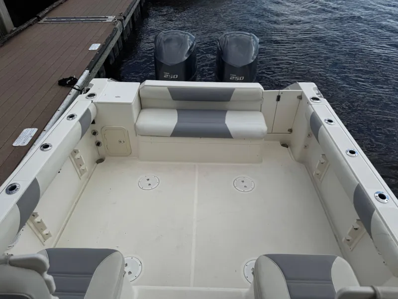 Slide: The Image of 1999 Pursuit 2870 Walkaround boat with spacious deck and twin engines at dock. - 29