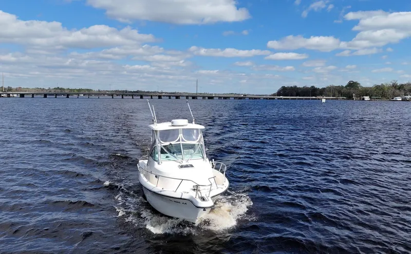 Slide: The Image of 1999 Pursuit 2870 Walkaround boat cruising on a sunny day with blue skies. - 3