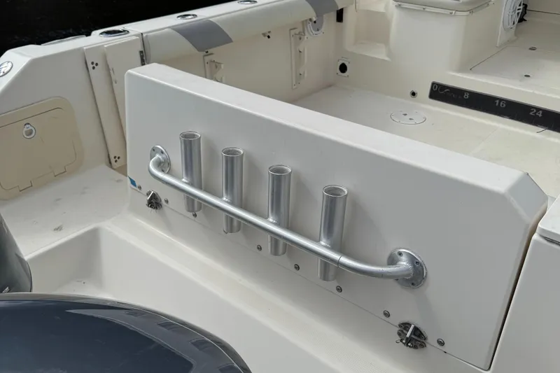 Slide: The Image of 1999 Pursuit 2870 Walkaround boat interior with rod holders and seating area. - 31
