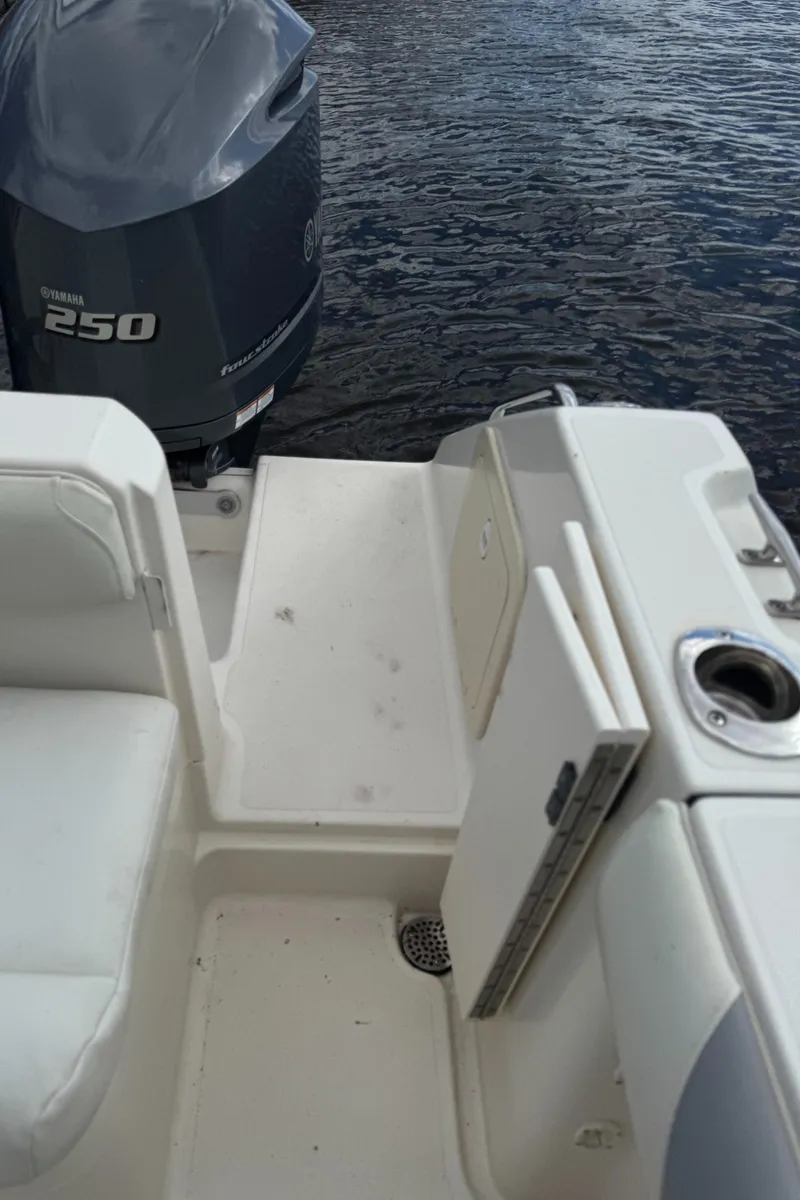 Slide: The Image of 1999 Pursuit 2870 Walkaround boat with Yamaha 250 engine, white seating, and cup holder. - 32