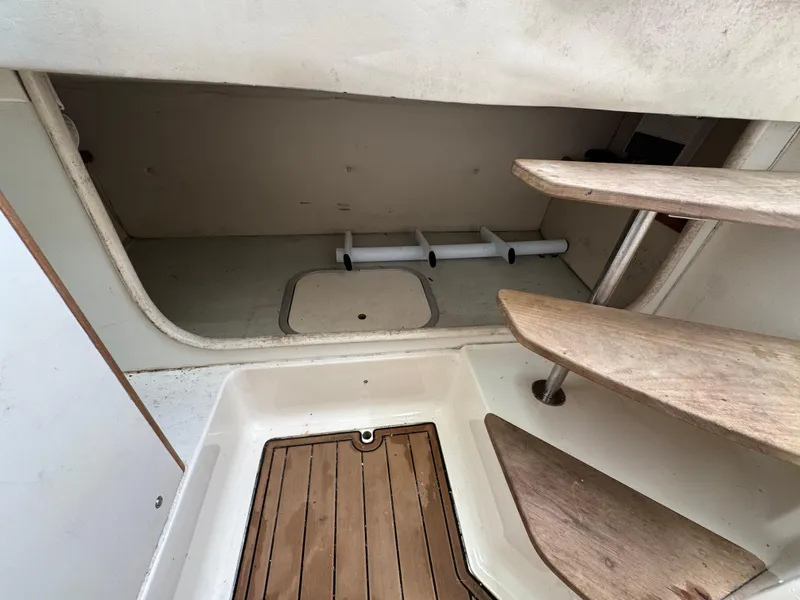 Slide: The Image of 1999 Pursuit 2870 Walkaround cabin interior with wooden steps and flooring. - 35