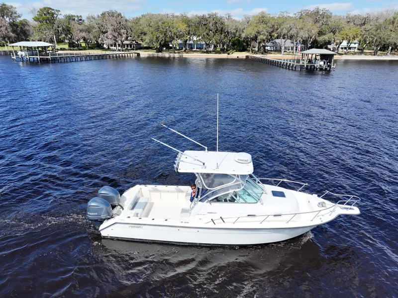 Slide: The Image of 1999 Pursuit 2870 Walkaround boat cruising on a scenic river. - 4