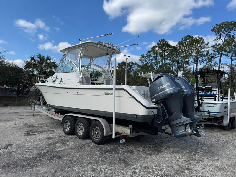 Slide: The Image of 1999 Pursuit 2870 Walkaround boat on trailer with Yamaha engines, parked outdoors. - 41